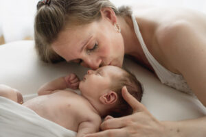 Newborn shooting auf Beanbag in Decke bekommt Kuss von Mutter in Eislingen